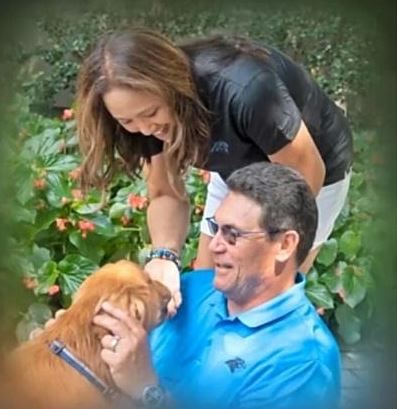 Stephanie Rivera and her husband Ron Rivera playing with their dog